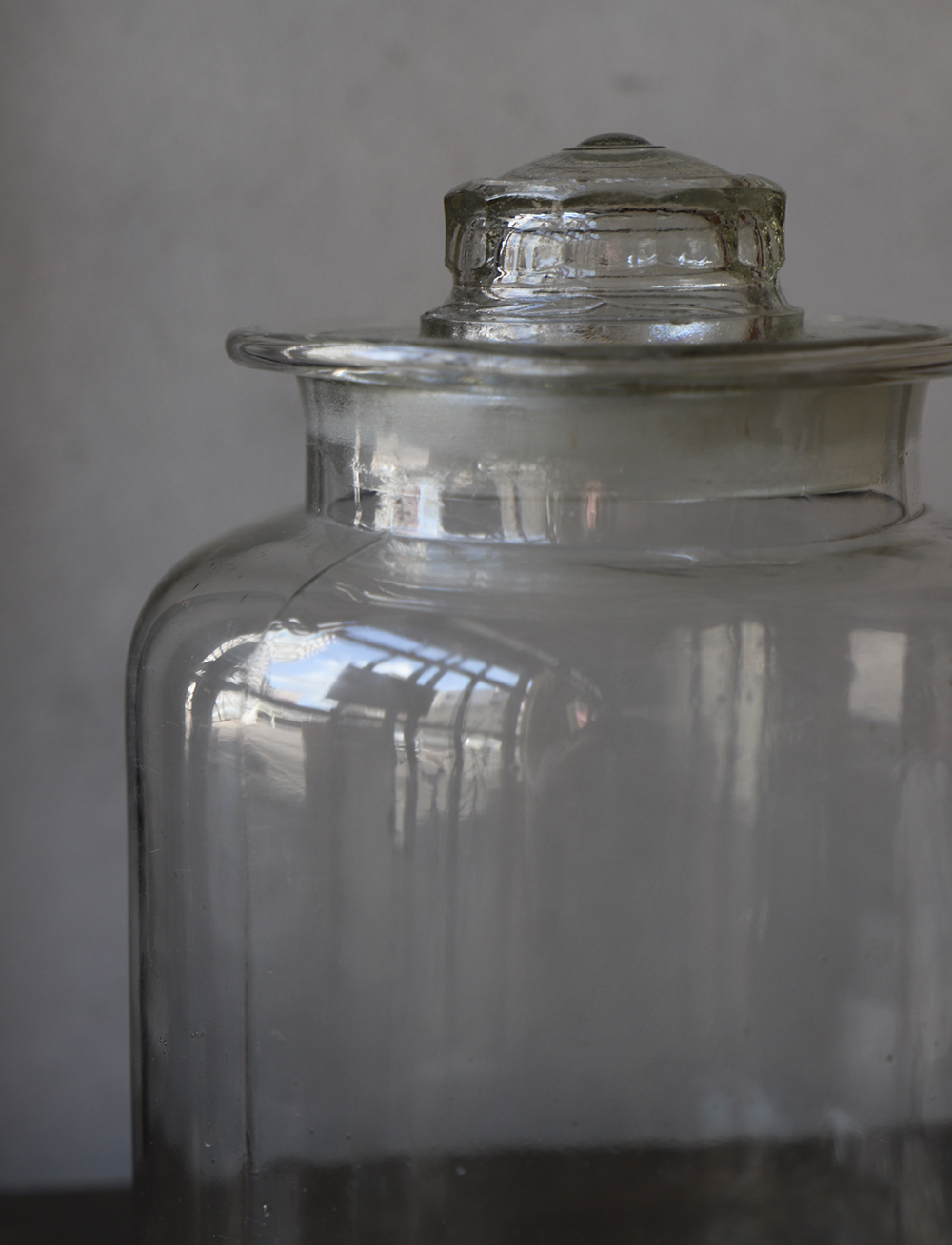 すっきりとしたデザインの蓋付きの古いガラス瓶